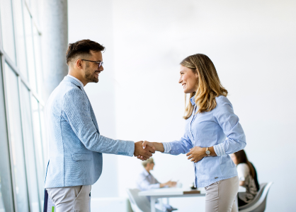 man and woman shaking hands and smiling